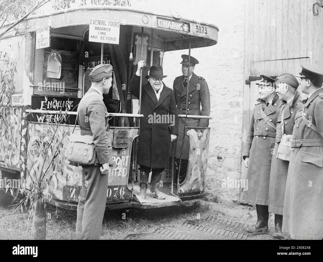 SIR KINGSLEY WOOD, SECRECTARY OF STATE FOR AIR, ON A TOUR OF THE RAF IN FRANCE 1939 - Sir Kingsley Wood, Secretary of State for Air, has completed a tour of the R.A.F. in France. Sir Kingsley Wood on a bus converted to office use clearly enjoys the slogans. Behind him is the Deputy Chief of the Air Staff. Officers on right -left to right -Air Vice Marshal P..H.L. Playfair, Officer Commanding R.A.F. in France, and two of his staff -Group Captain A.H. Wann and Air Commodore J.C. Quinnell Stock Photo