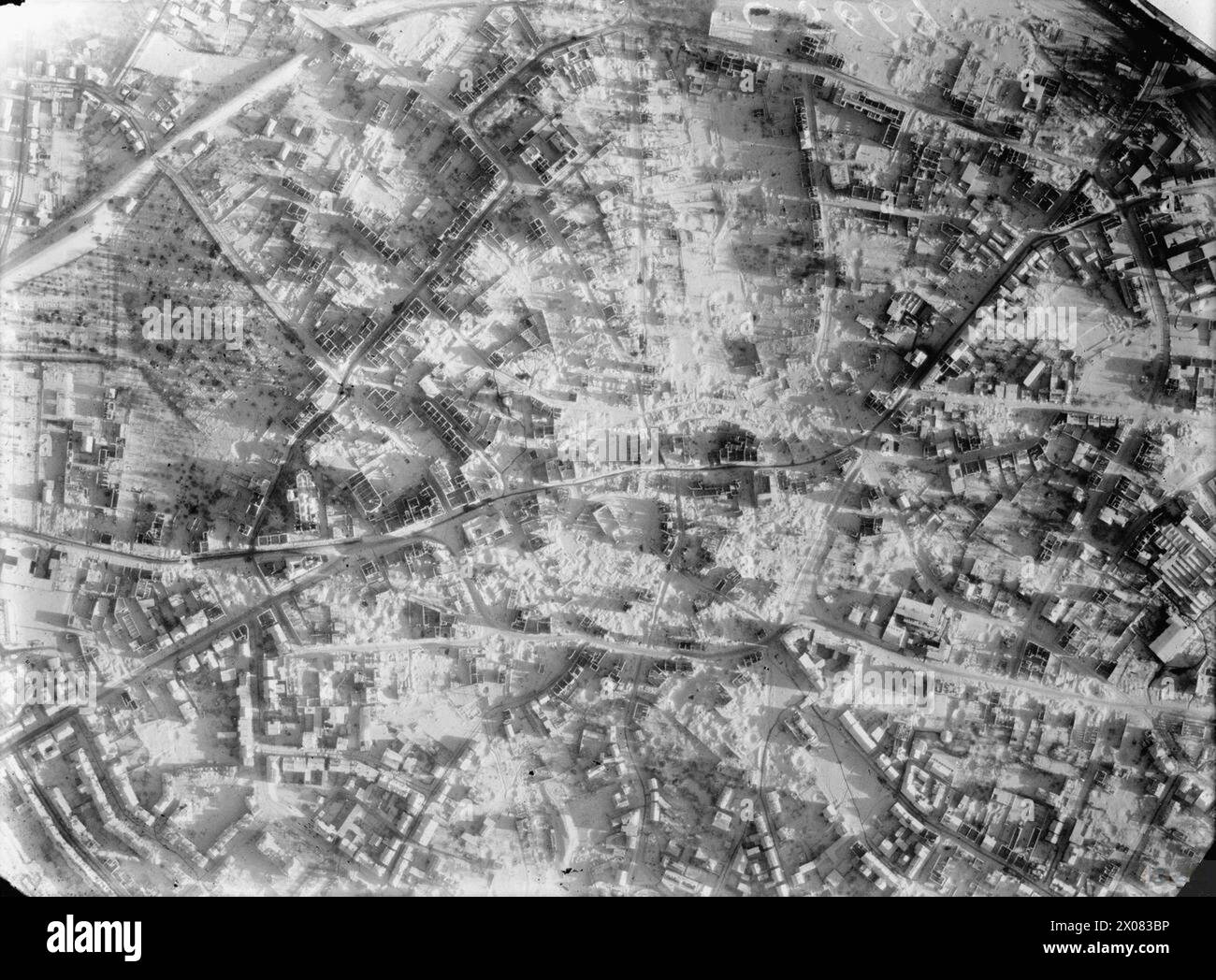 ROYAL AIR FORCE: OPERATIONS BY THE PHOTOGRAPHIC RECONNAISSANCE UNITS, 1939-1945. - Vertical photographic-reconnaissance aerial showing the devastated town centre of Solingen, Germany, in the winter snow; the result of a daylight raid by 173 Avro Lancasters of No. 3 Group, Bomber Command. This successful attack was delivered using G-H blind-bombing radar because of the complete cloud cover over the target. 1,300 dwellings and 18 industrial buildings were destroyed and 1,600 more buildings severely damaged. Between 1,224 and 1,882 people were killed and a further 2,000 injured  Royal Air Force, Stock Photo