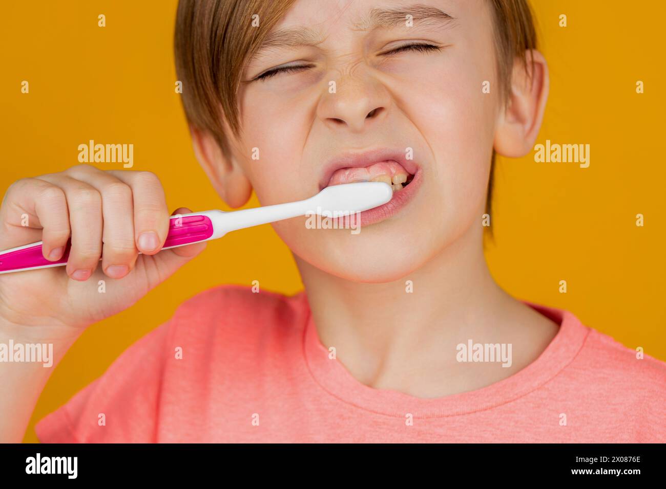 Dental hygiene. Little kid brushing her teeth. Kid boy brushing teeth. Boy toothbrush white toothpaste. Health care, dental hygiene. Child shows Stock Photo