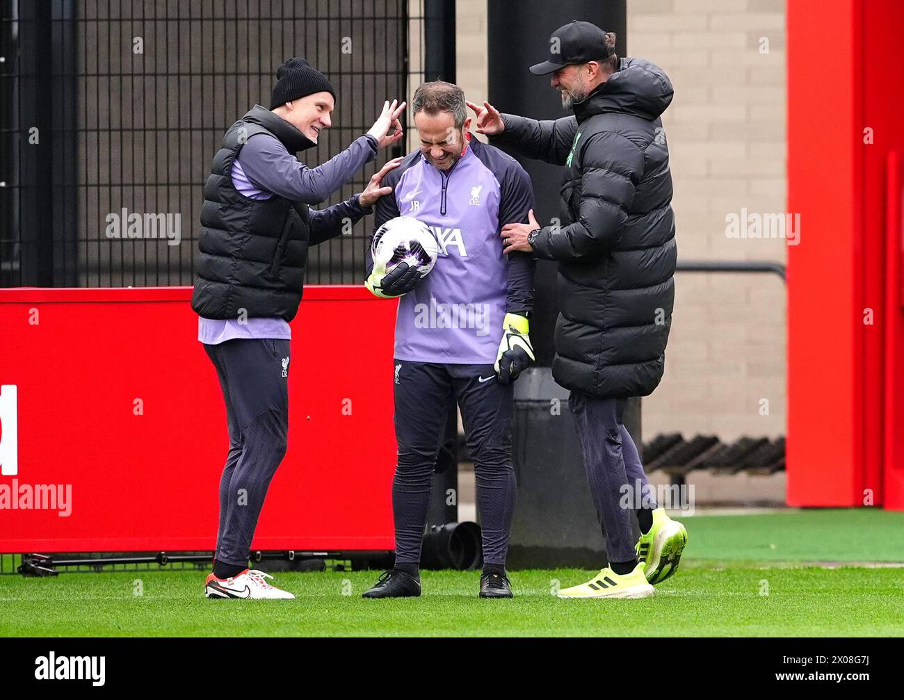 Liverpool manager Jurgen Klopp (right) and goalkeeping coach Claudio Taffarel (left) appear to flick assistant goalkeeping coach Jack Robinson during the training session at the AXA Training Centre, Liverpool. Picture date: Wednesday April 10, 2024. Stock Photo
