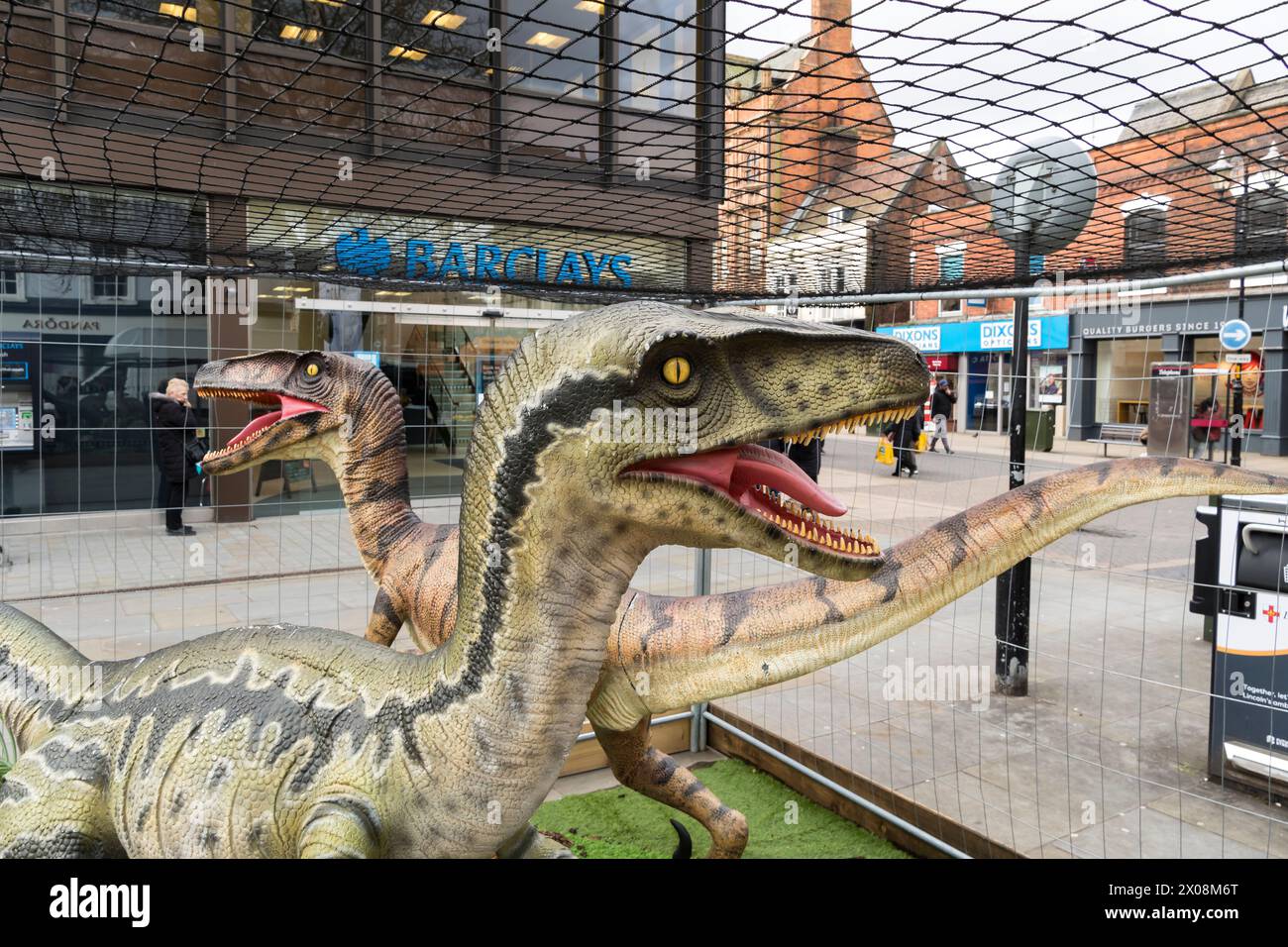 Two models of dinosaurs in cage, Cornhill, Lincoln City, Lincolnshire, England, UK Stock Photo