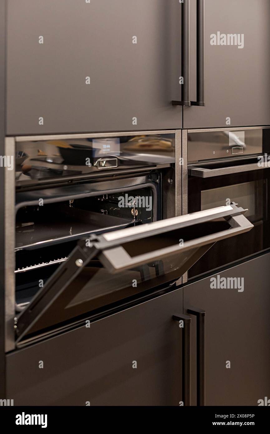 Modern kitchen with an open built-in oven and sleek dark cabinets Stock ...