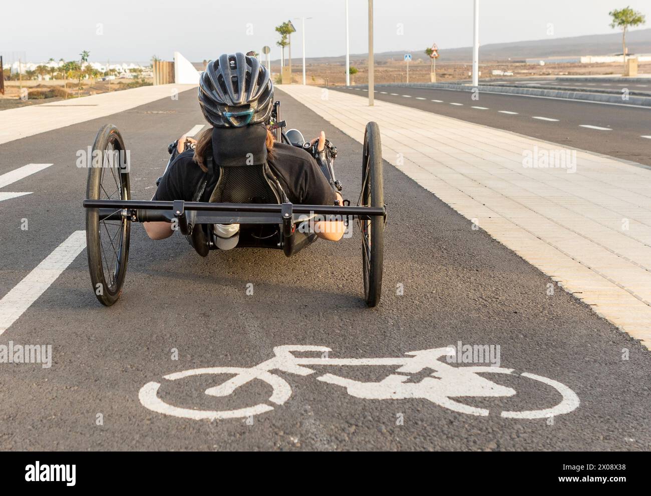 Unrecognizable determined woman on a handbike trains on a bike path