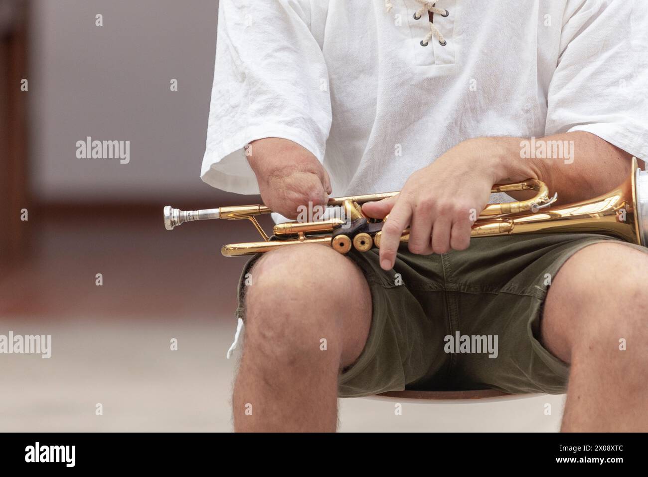 Detail shot of a onearmed musician adjusting the valves of a golden