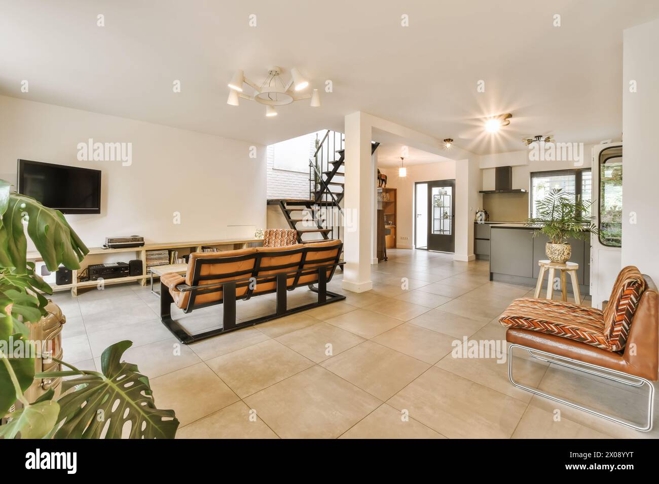 A well-lit, modern living room with an open floor concept featuring a ...