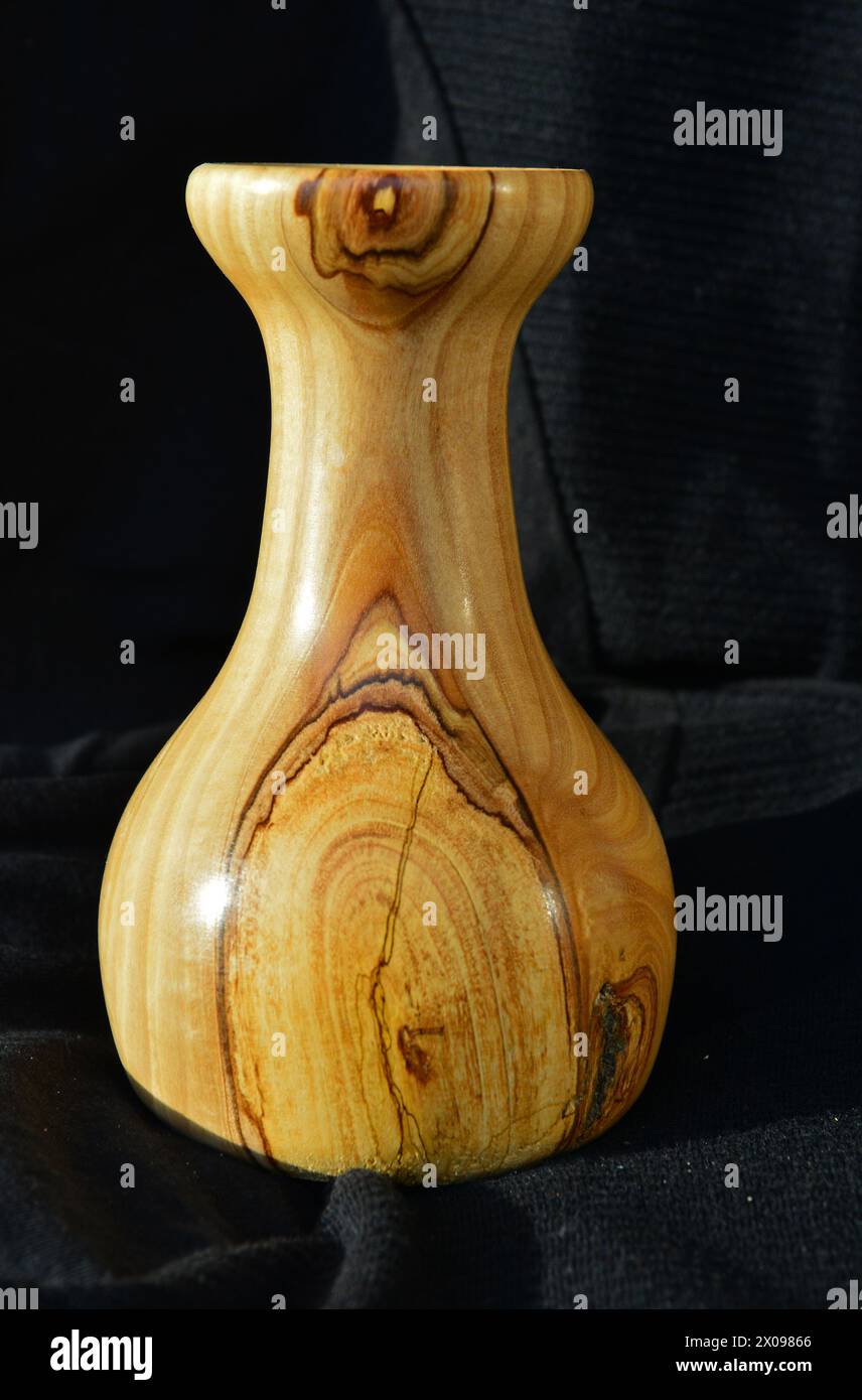 Hand-turned vase cut from olive tree wood. Side view, against a black backcloth Stock Photo