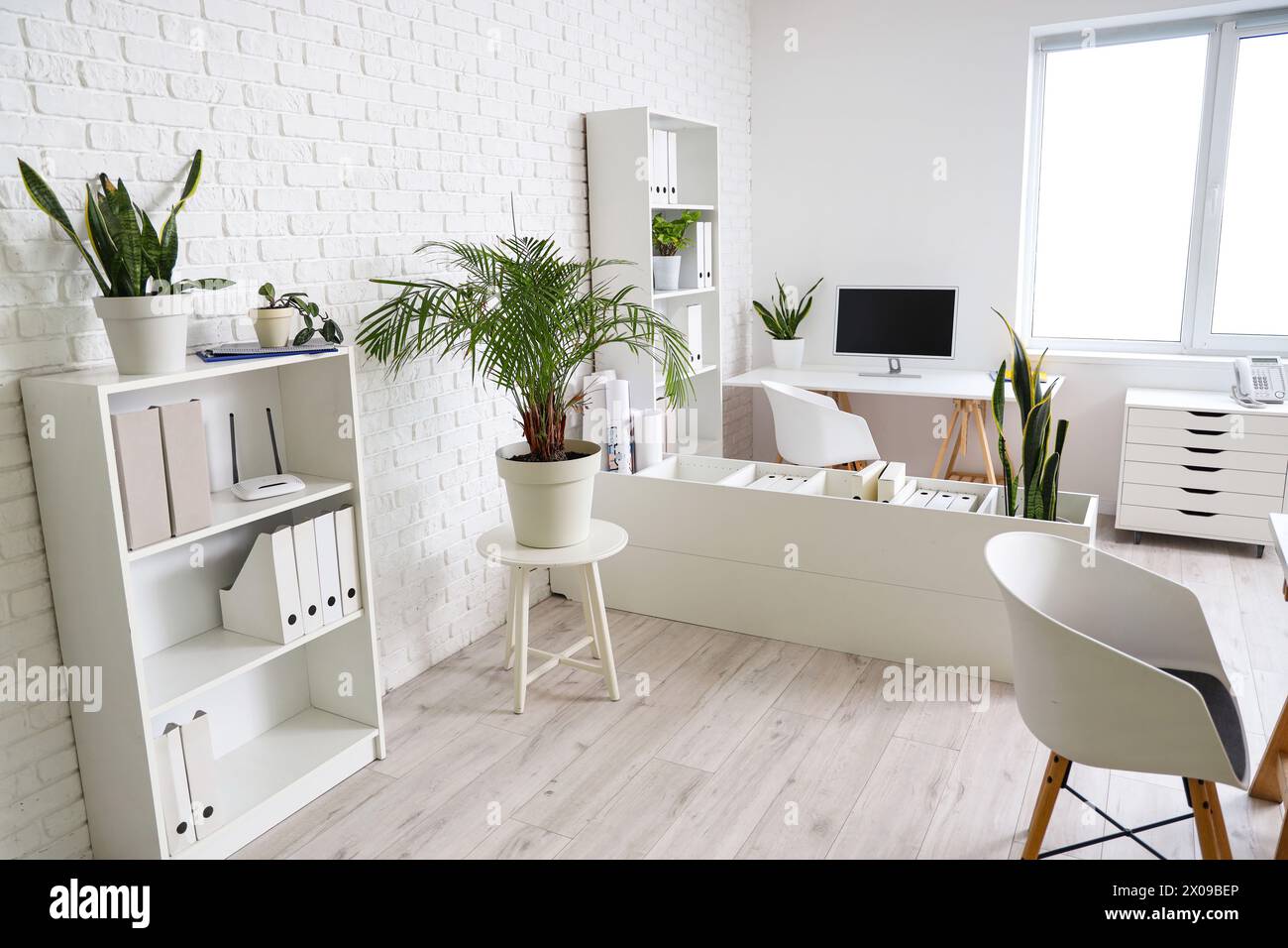 Interior of office with table, shelf units and plants Stock Photo - Alamy
