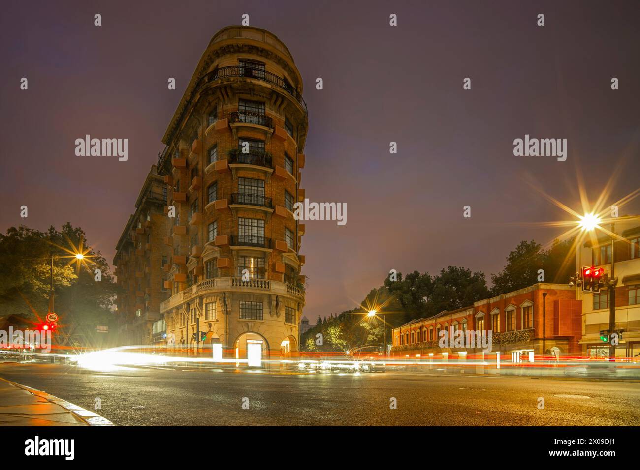 A busy road junction in the French Concession in Shanghai at night with light trails Stock Photo