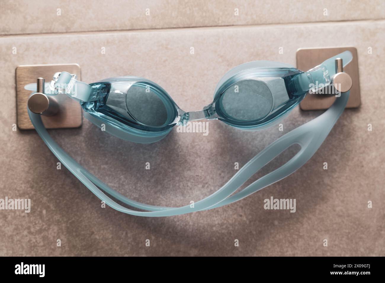 Close up of swimming goggles hanging on a hook in a modern shower room interior. The goggles are neatly displayed and ready for use adding a sporty t Stock Photo Alamy