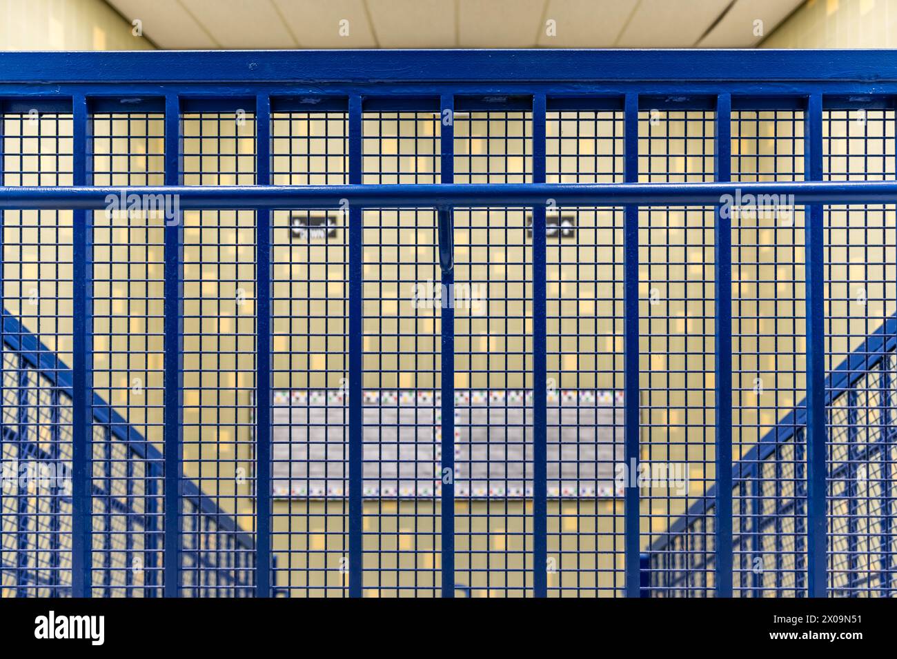 Close-up photo of a blue metal railing at the top of a school staircase ...