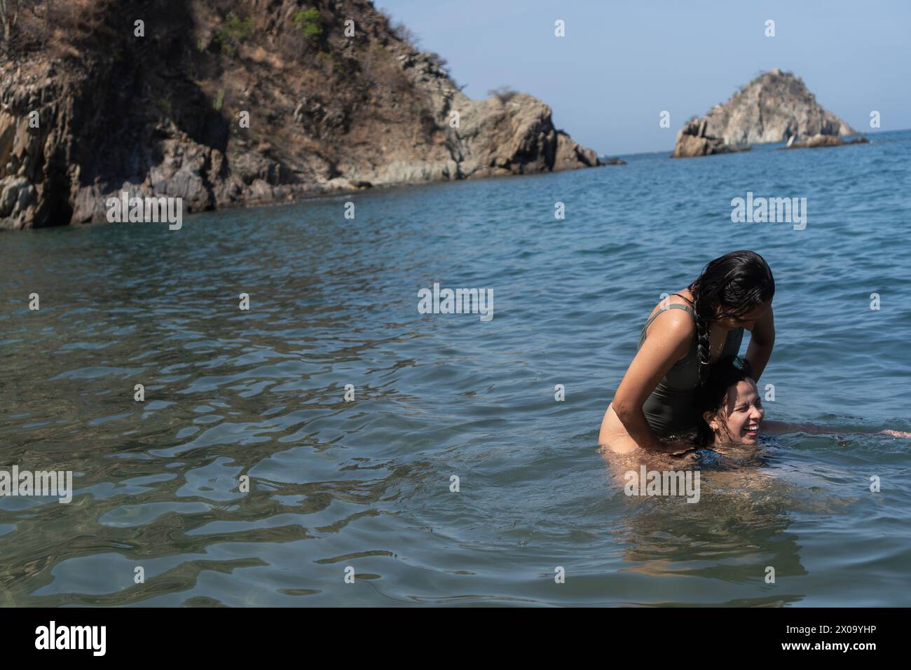 Two individuals enjoying playful times in coastal waters. Stock Photo