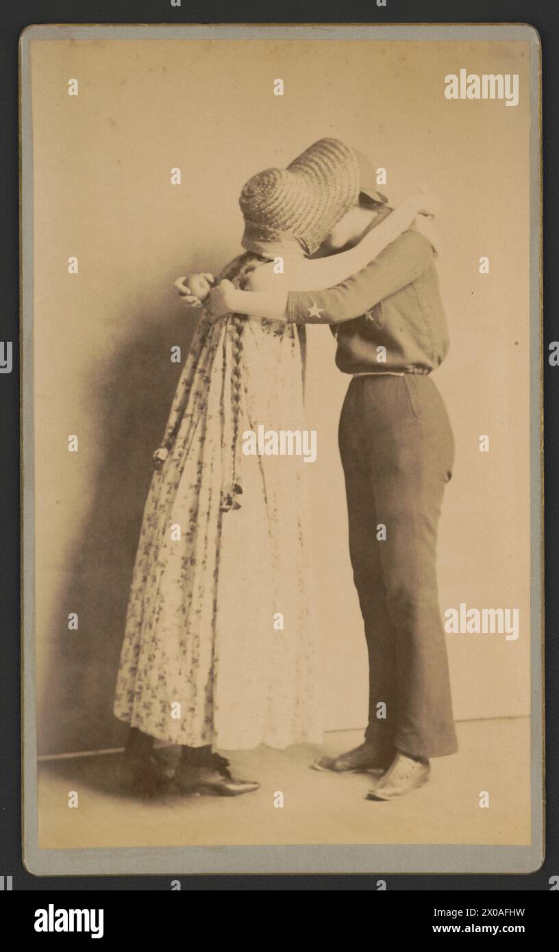 Two women dressed in possible theatrical costumes embracing and kissing. (Photo by Frances Benjamin Johnston, circa 1895) Stock Photo