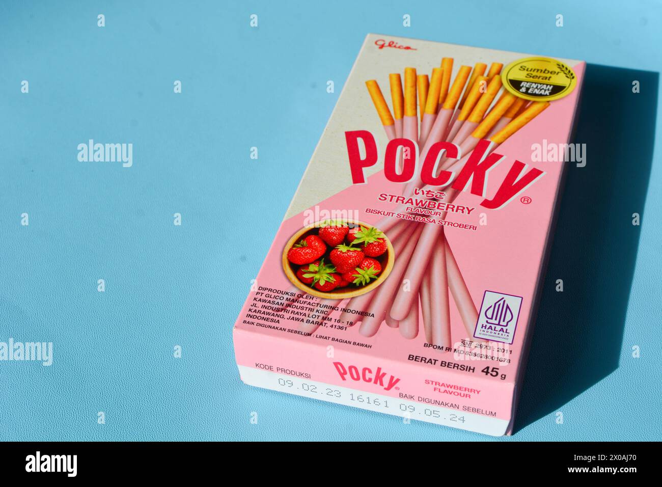 Wonosobo, Indonesia April 23, 2023: Pocky snacks with strawberry flavor in pink packaging. Against a blue background. Stock Photo