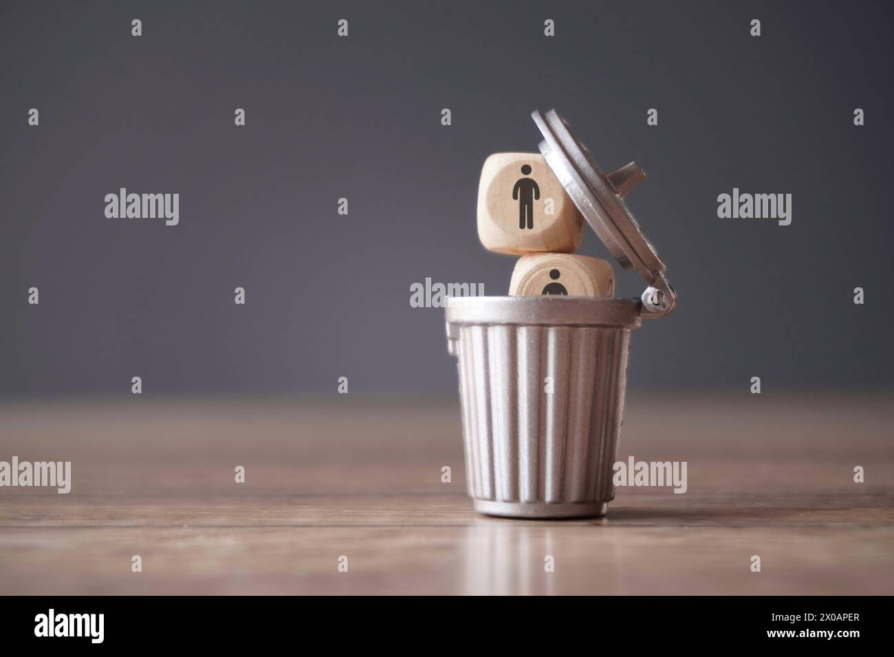 Relationship, remove toxic people concept. Wooden cube with people icon inside dustbin, trash can. Stock Photo