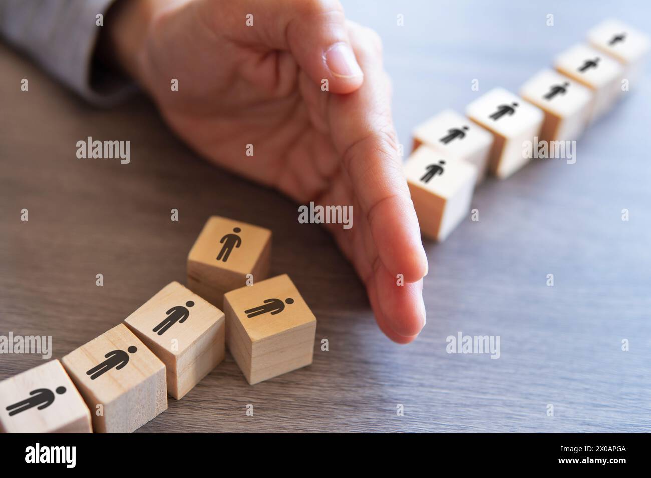 Hand separate group of people. Mass layoffs, downsizing concept. Stock Photo