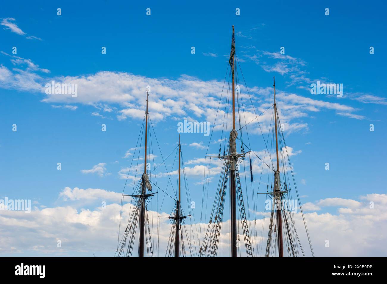 The masts of two tall ships against a clear blue sky. Mary Day and ...