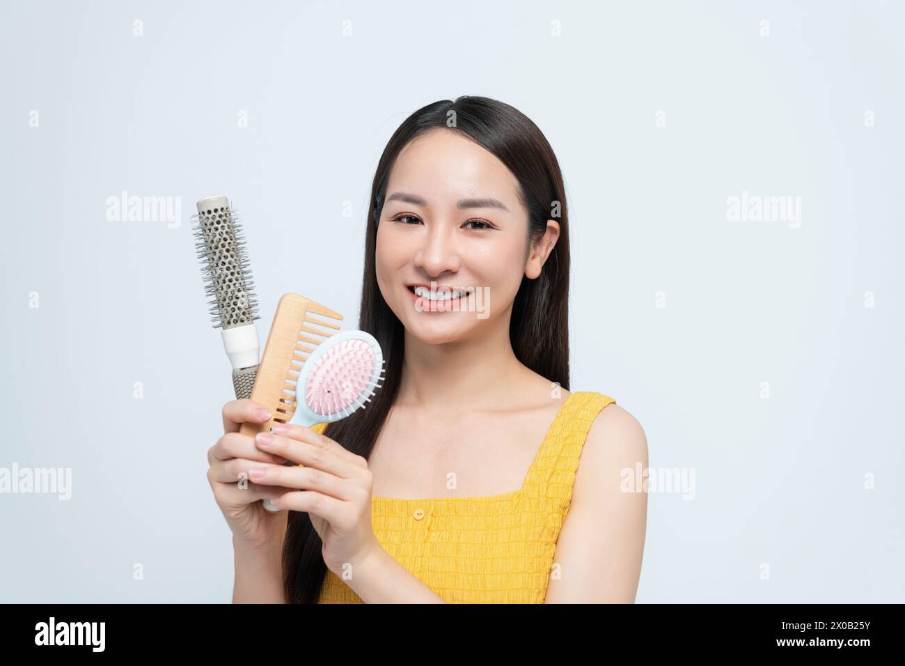 Woman holding hairbrush near face Stock Photo