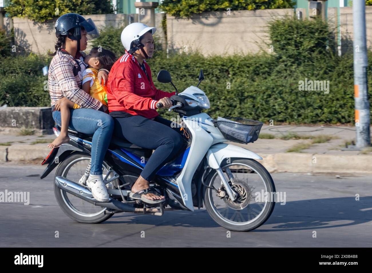 BANGKOK, THAILAND, MAR 24 2024, Women ride a motorcycle with a small child Stock Photo