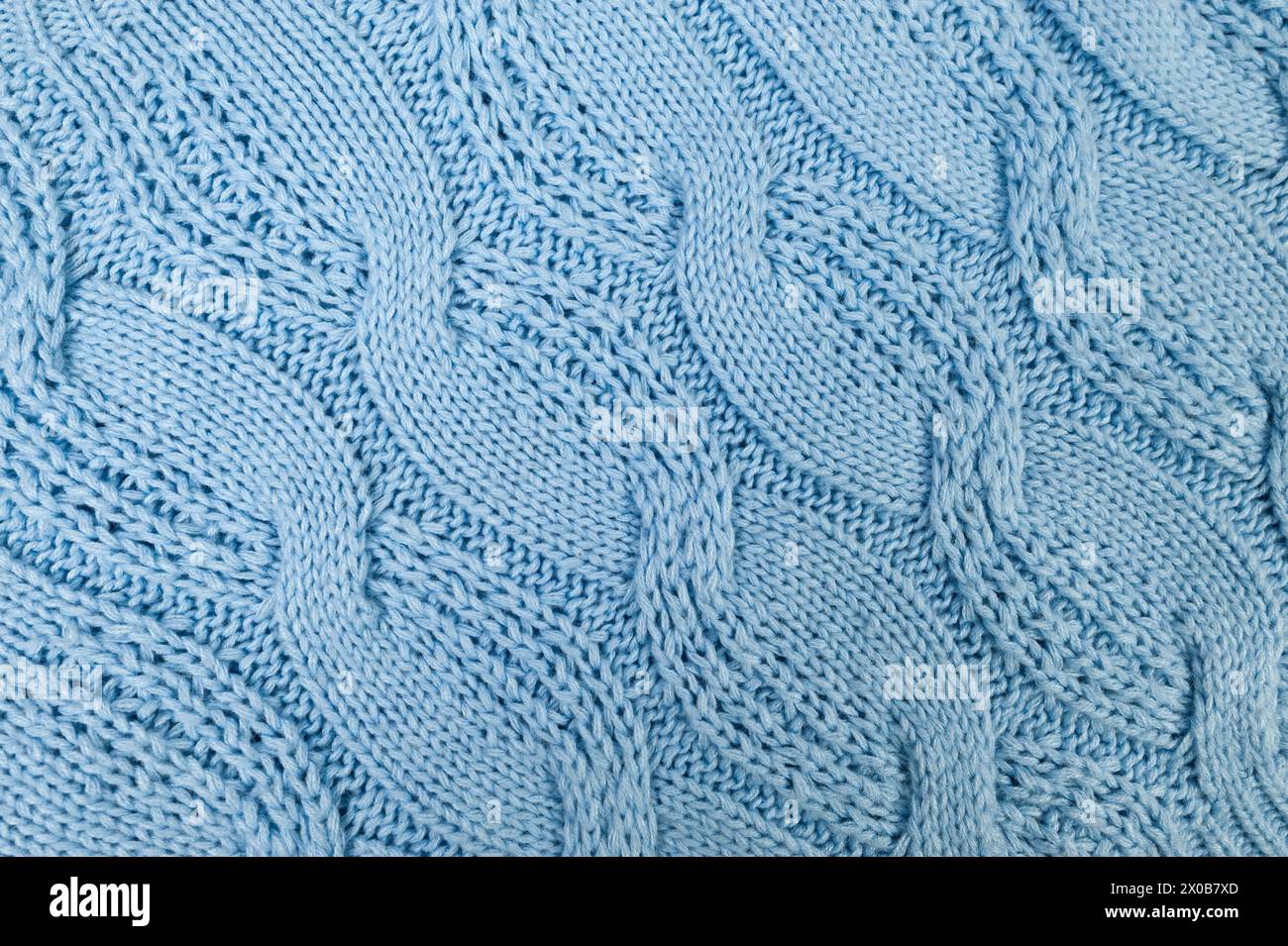 Blue knitted fabric background. Knitted braids texture. Stock Photo