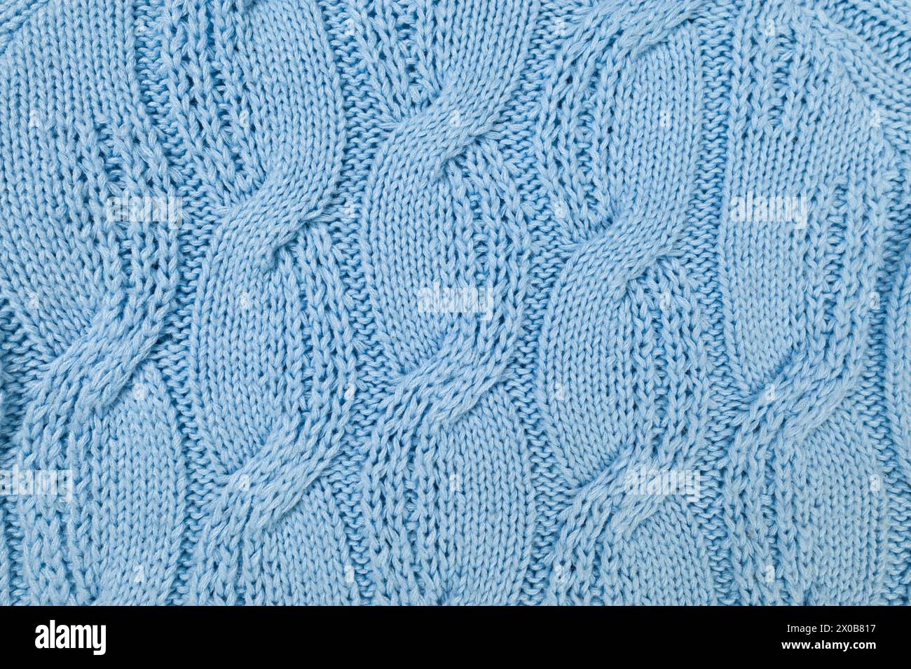 Blue knitted fabric background. Knitted braids texture. Stock Photo