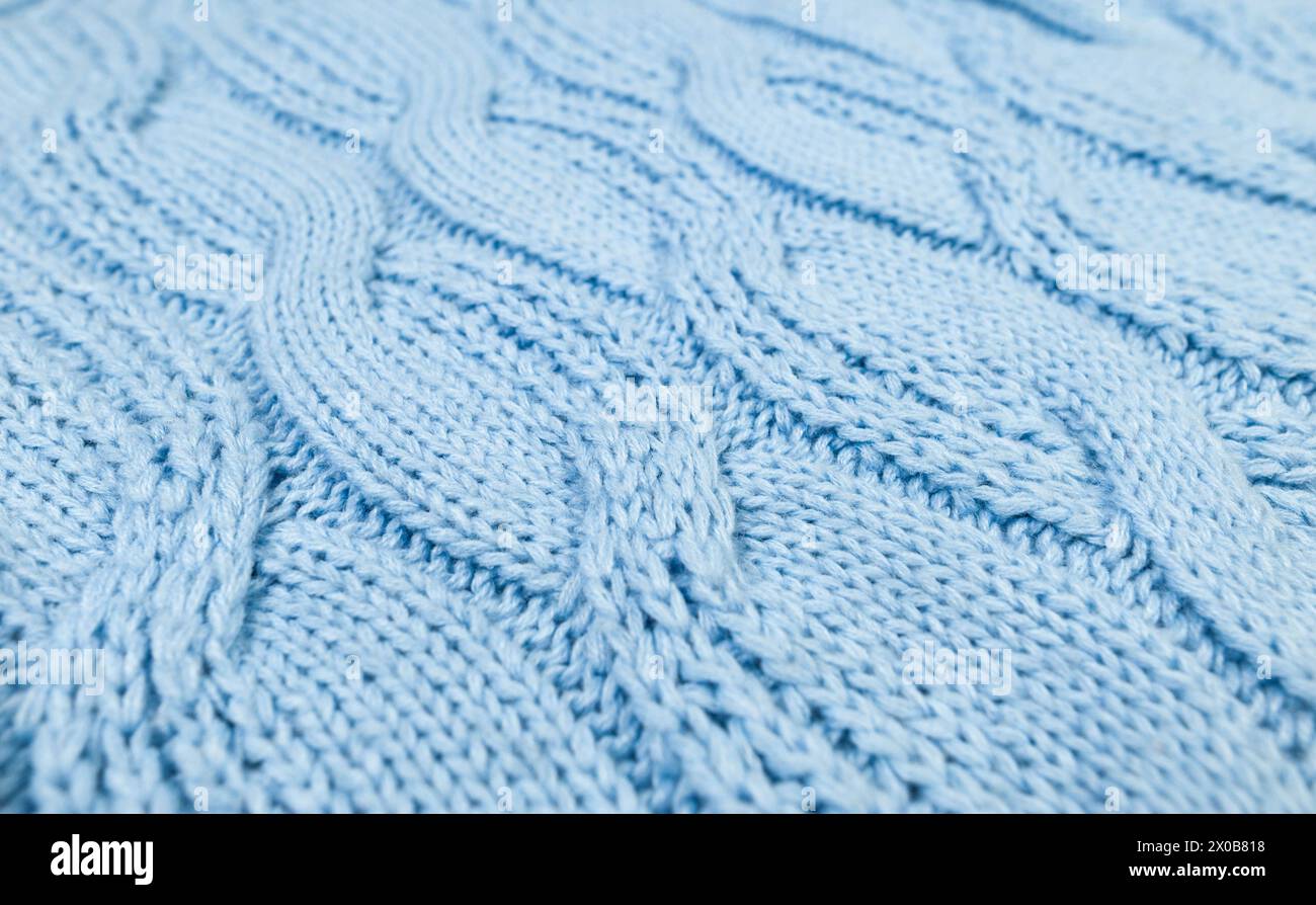Blue knitted fabric background. Knitted braids texture. Stock Photo