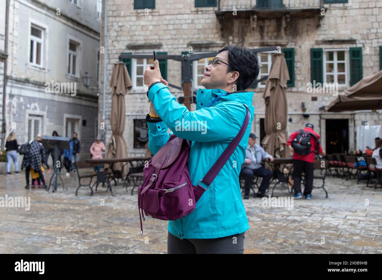 Kotor, Montenegro, Apr 30, 2019: A tourist takes photos of the St. Tryphon Square in Old Town Stock Photo
