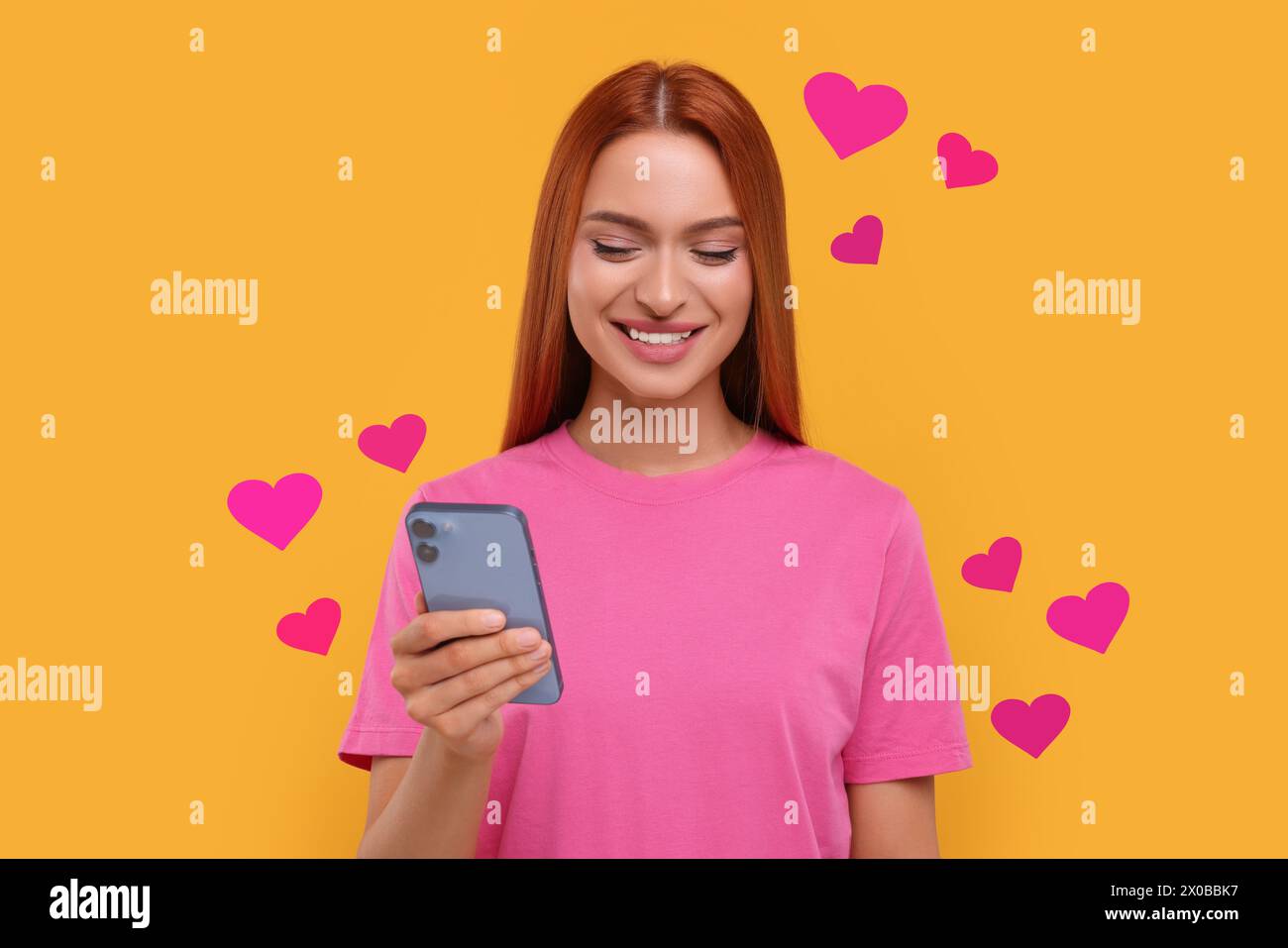 Long distance love. Woman chatting with sweetheart via smartphone on golden background. Hearts flying out of device and swirling around her Stock Photo