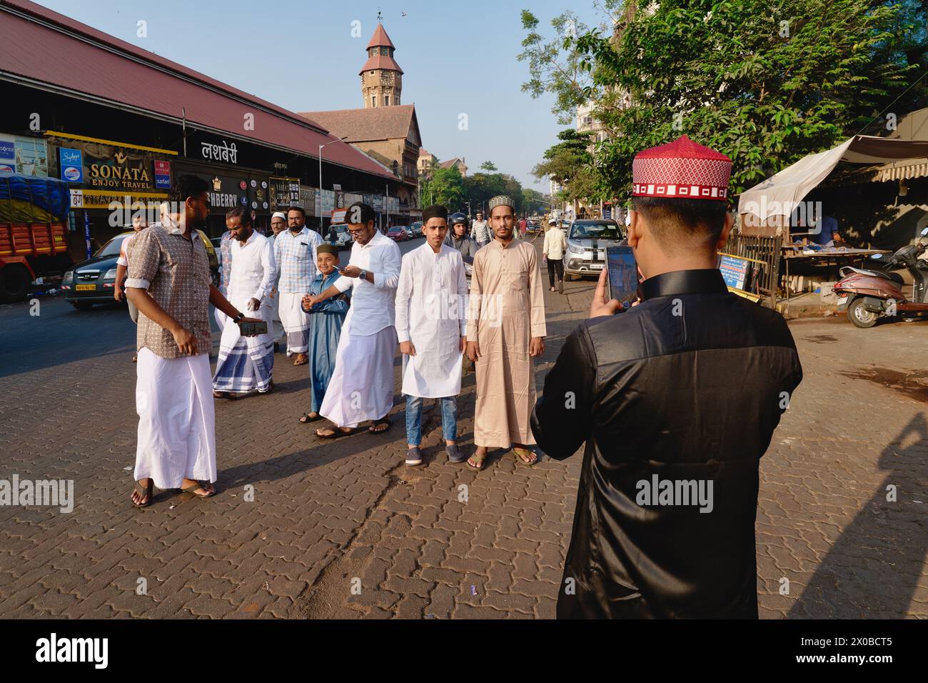 On the occasion of Eid (Id) Festival, a group of Muslim men take a souvenir photograph to the backdrop of Crawford Market in Mumbai, India Stock Photo