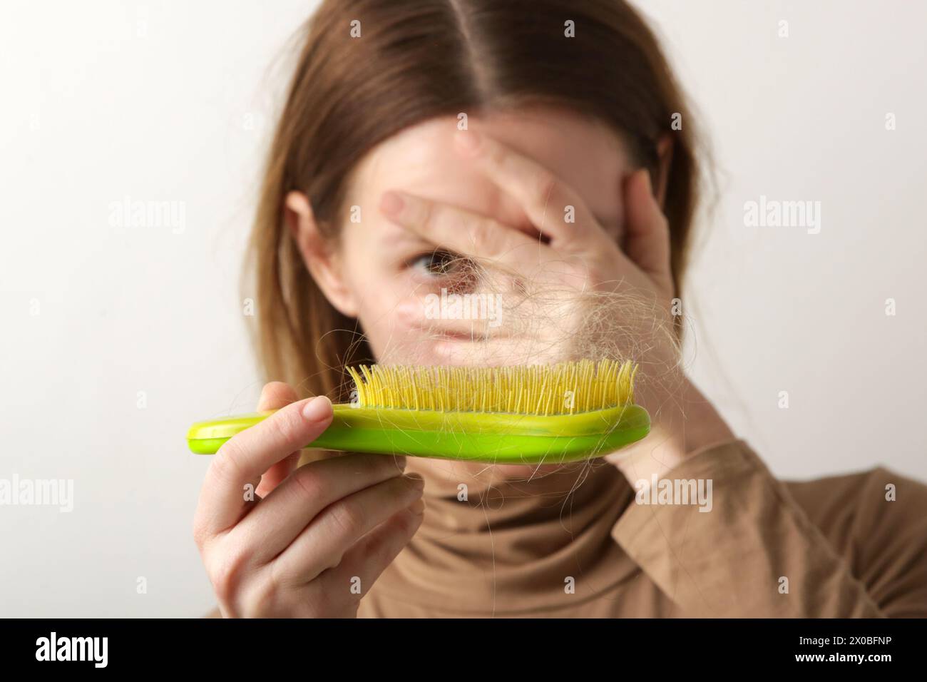 Woman holding detangler hair brush full of hair that has fallen out, loss hair problem Stock Photo