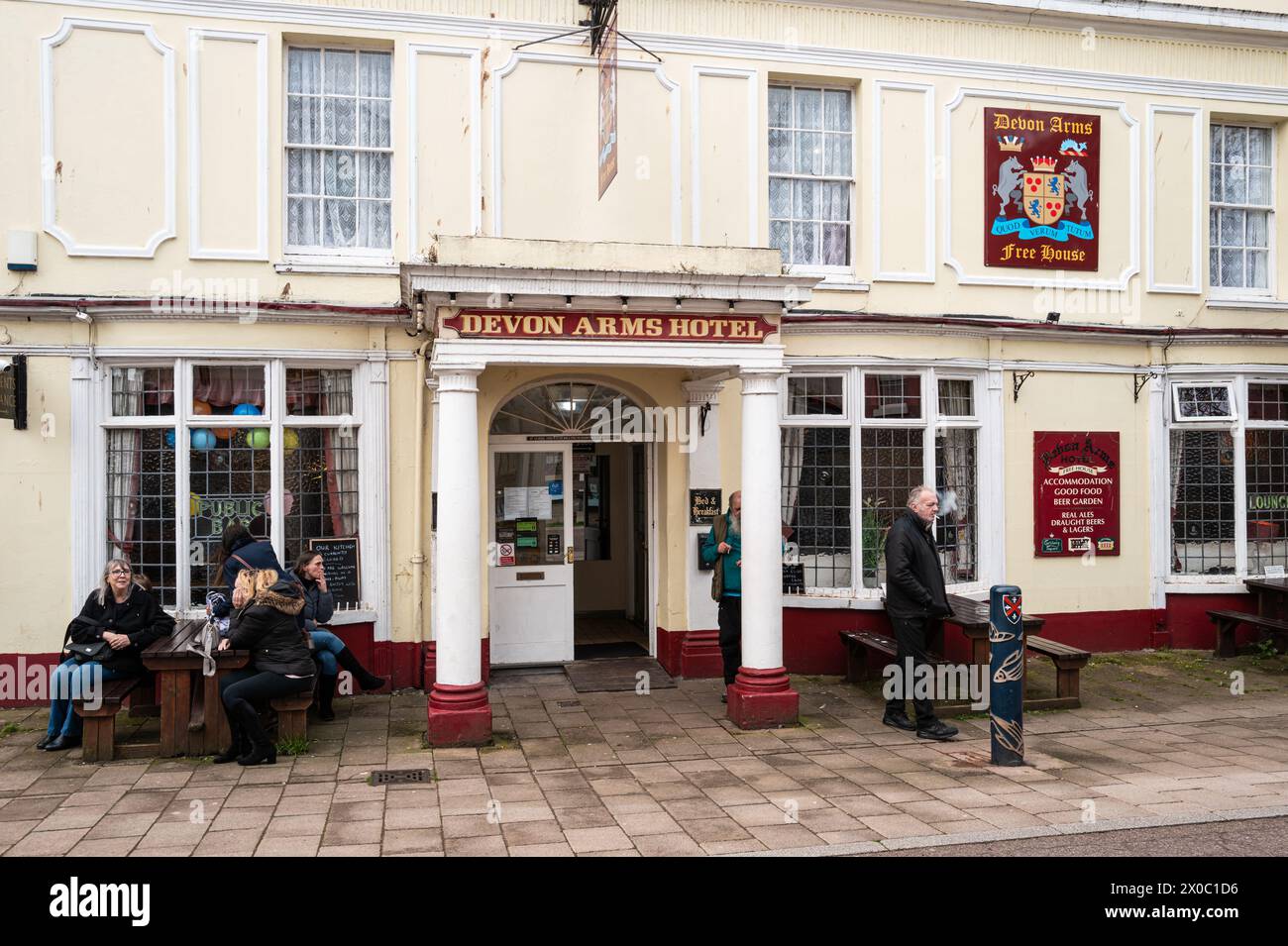 People sitting outside the Devon Arms public house in Teignmouth, Devon, UK. Colour photography. Stock Photo