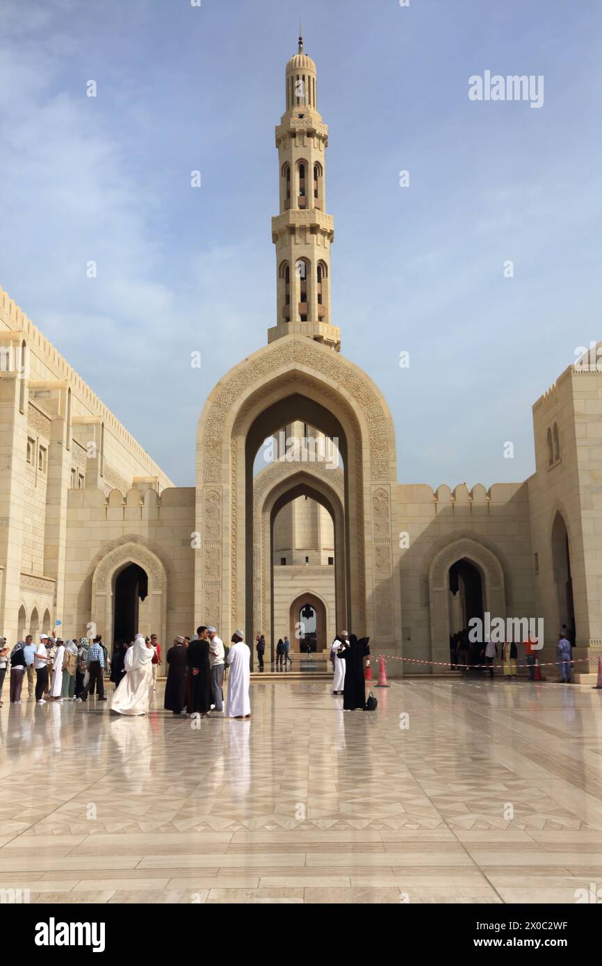 Sultan Qaboos Grand Mosque Tourists and Locals by Archway and Minaret Muscat Oman Stock Photo