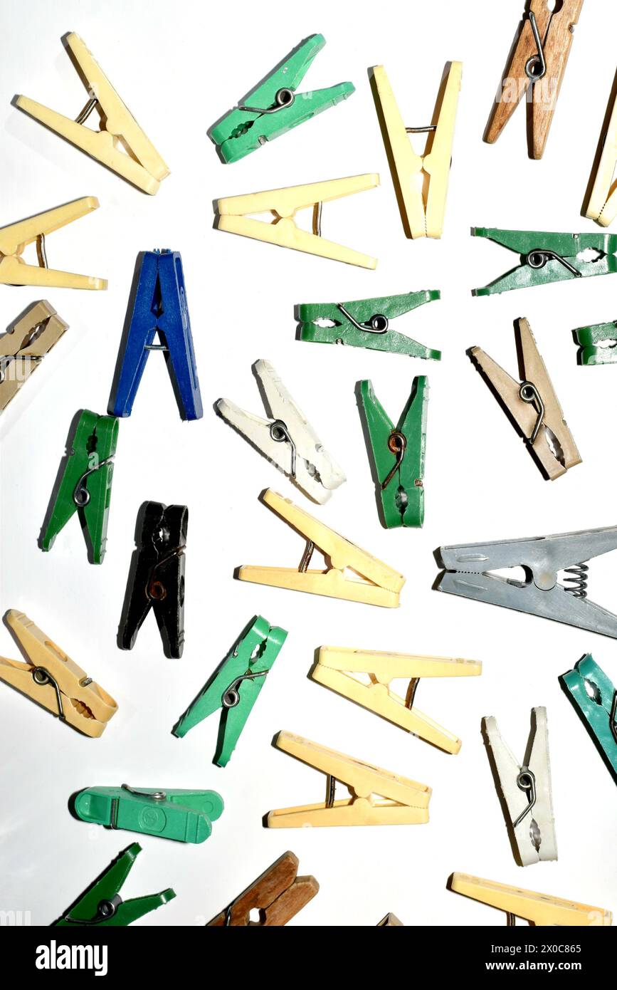 Textural pattern created by multi-colored clothespins randomly scattered on a white background. Stock Photo