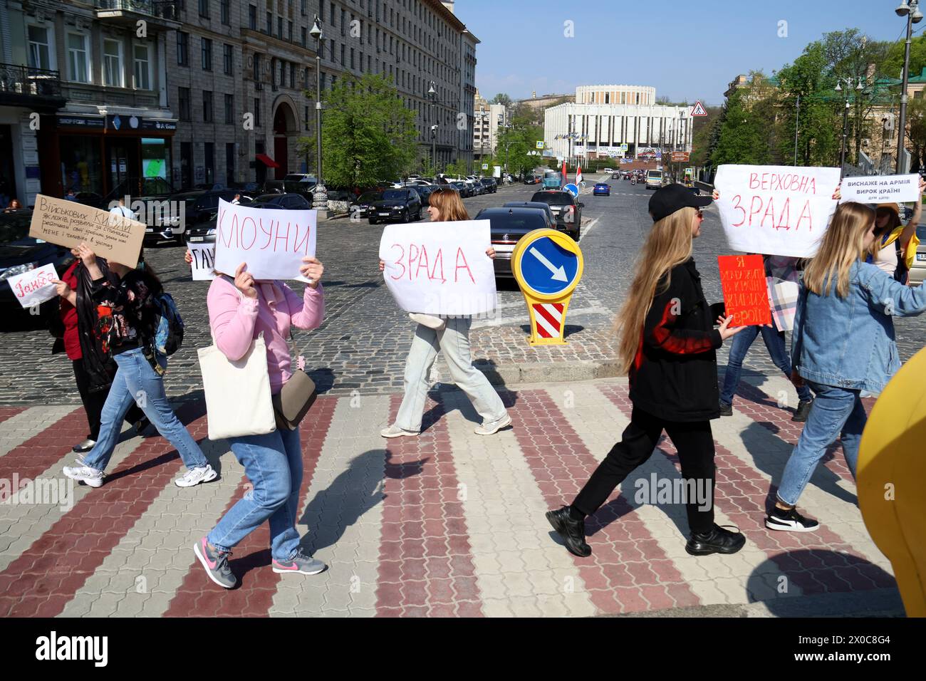 KYIV, UKRAINE - APRIL 11, 2024 - Families of Ukrainian soldiers hold placards as they block the street during a picket to demand clear terms of military service, outside the Valerii Lobanovskyi Dynamo Stadium, Kyiv, capital of Ukraine. Stock Photo