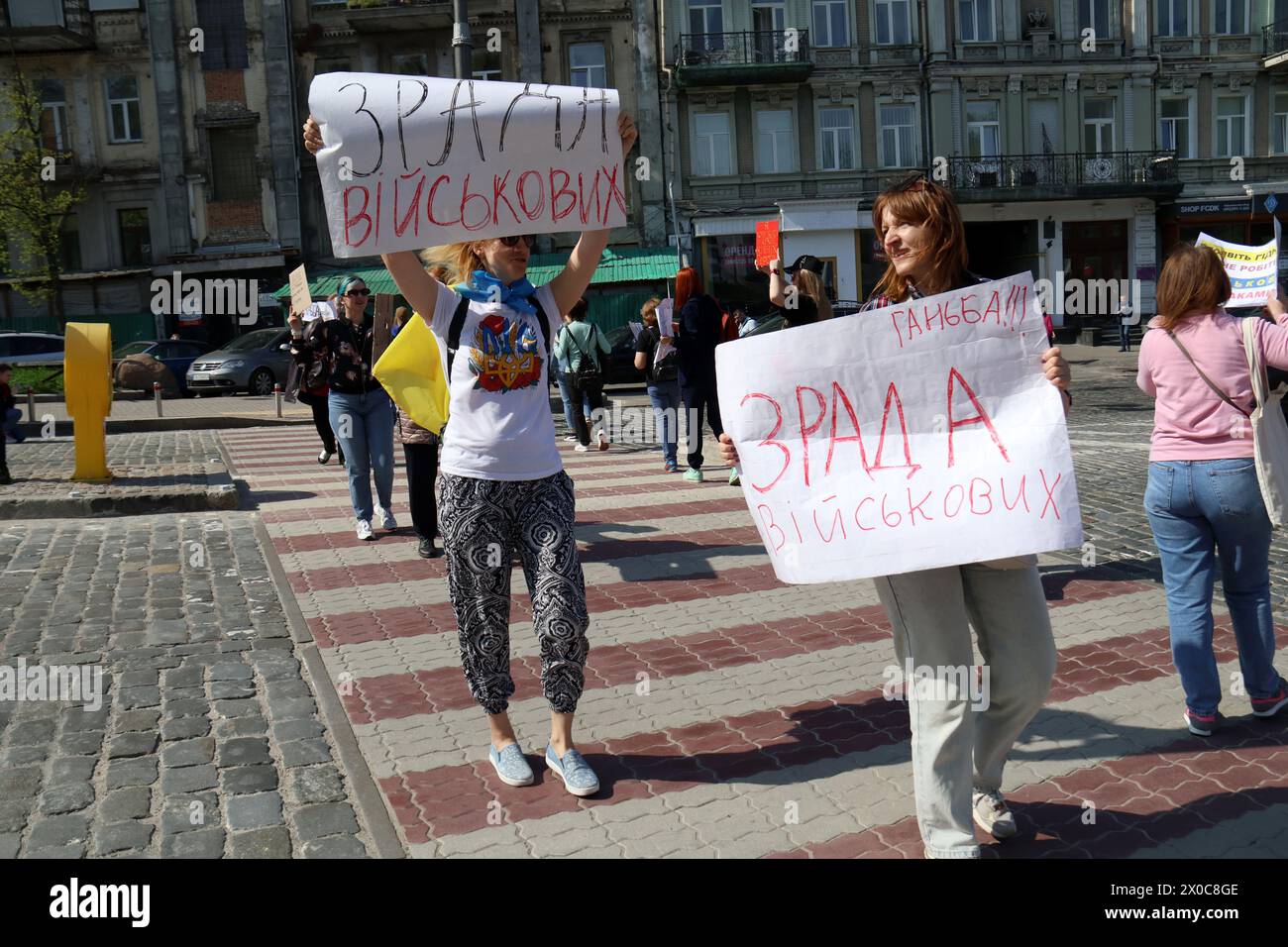 KYIV, UKRAINE - APRIL 11, 2024 - Families of Ukrainian soldiers hold placards as they block the street during a picket to demand clear terms of military service, outside the Valerii Lobanovskyi Dynamo Stadium, Kyiv, capital of Ukraine. Stock Photo