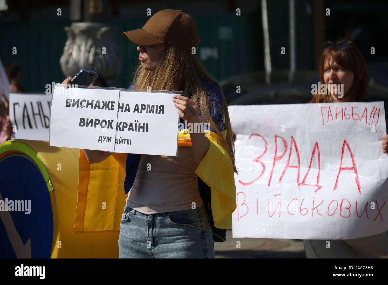 KYIV, UKRAINE - APRIL 11, 2024 - Families of Ukrainian soldiers hold placards as they block the street during a picket to demand clear terms of military service, outside the Valerii Lobanovskyi Dynamo Stadium, Kyiv, capital of Ukraine. Stock Photo