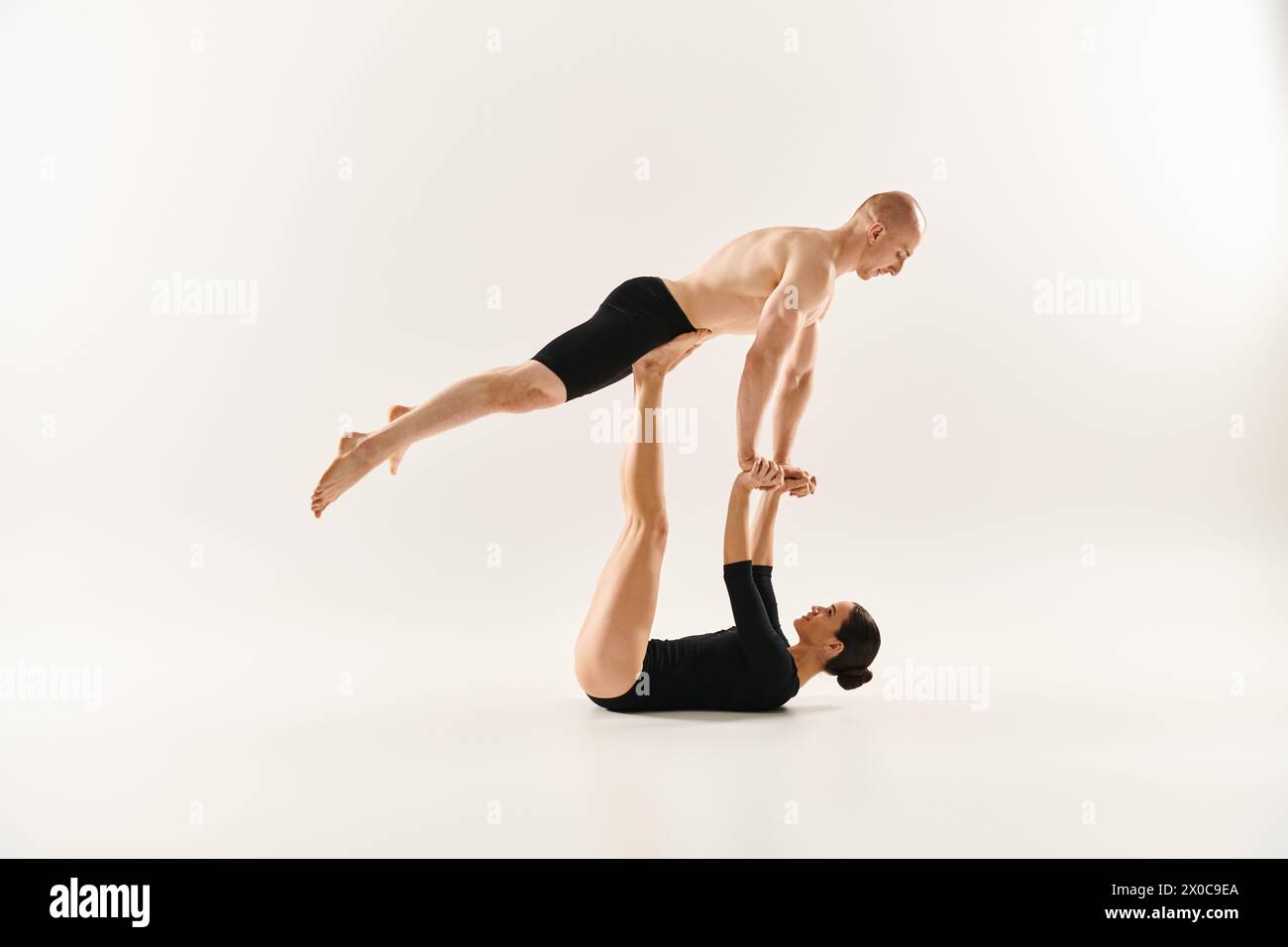 A man gracefully balances on woman hands in a stunning handstand display, showcasing strength and coordination. Stock Photo