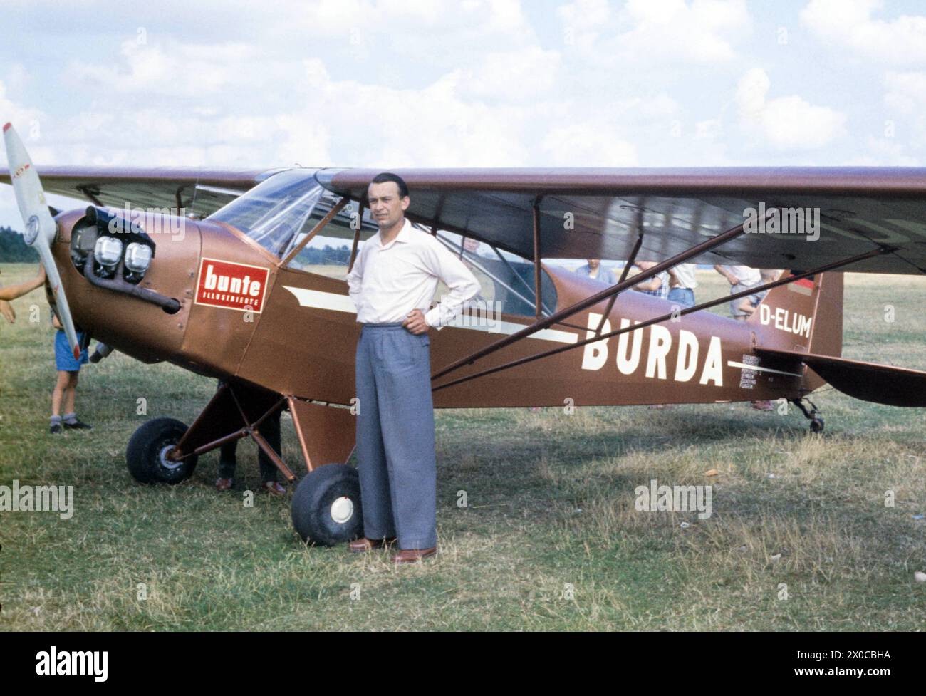 Ein Mann steht vor einer Piper PA-18 Super Cub der Burda-Staffel mit ...