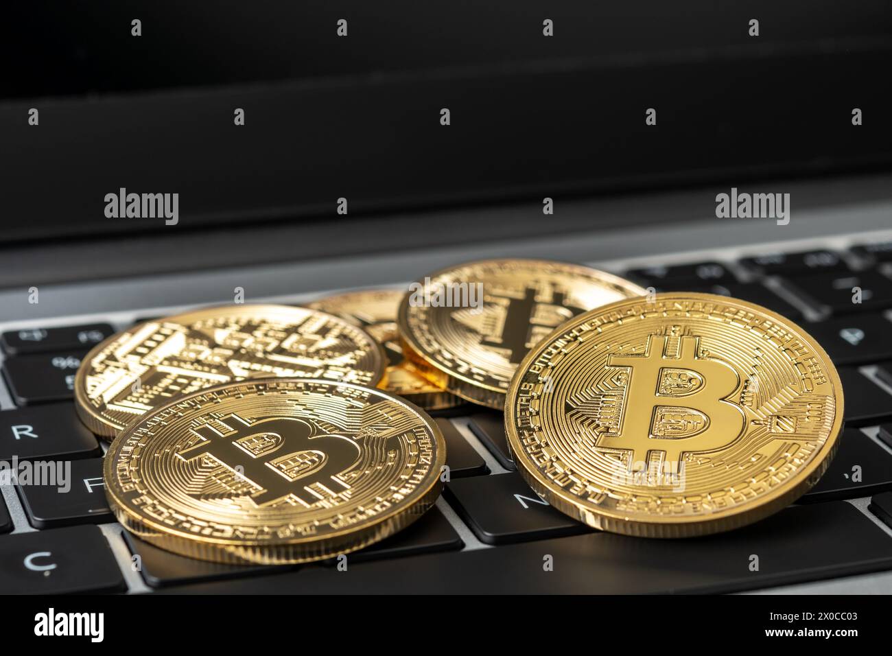 Bitcoin cryptocurrency gold coins on laptop. Stock Photo