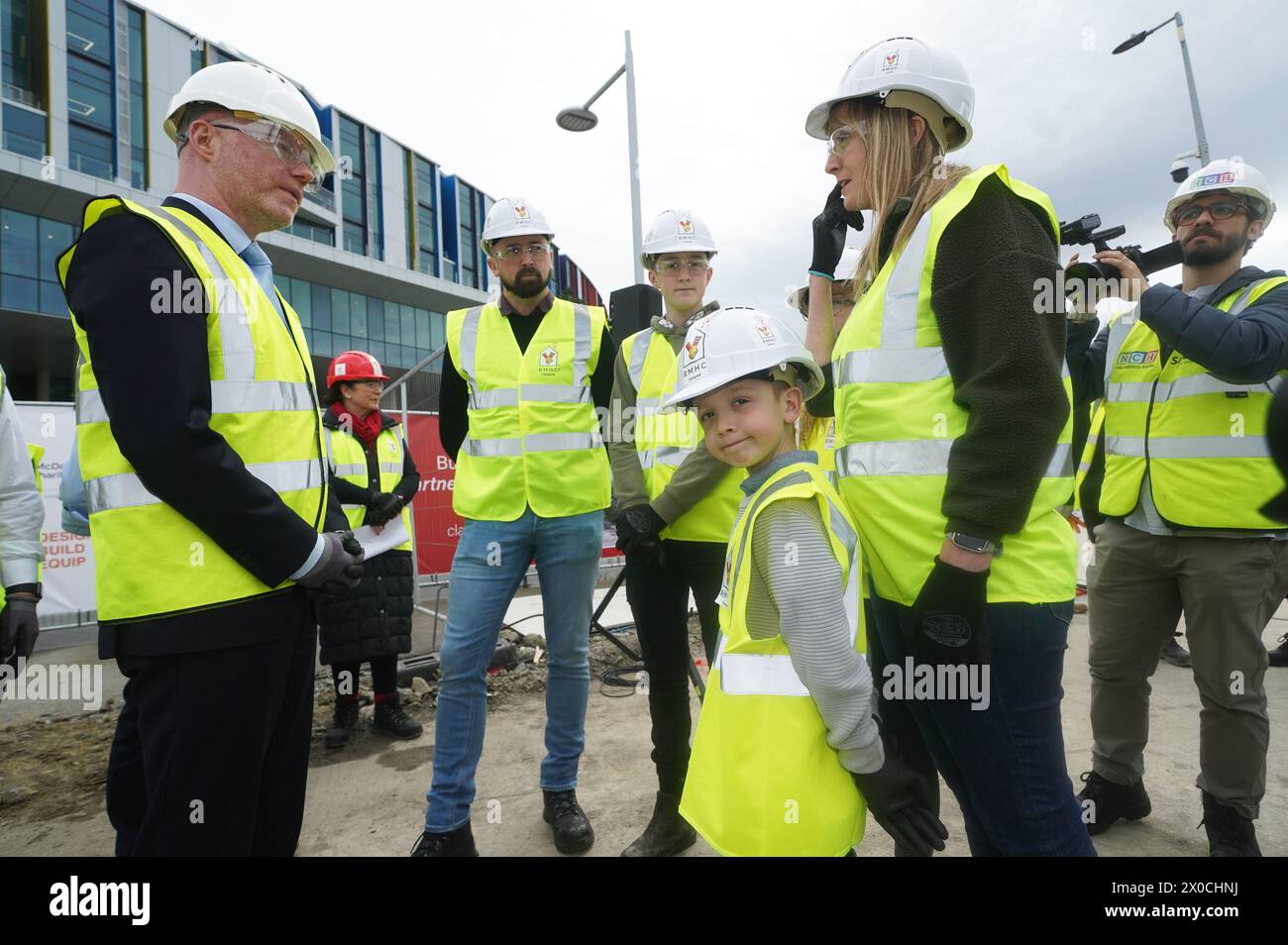Minister for Health Stephen Donnelly (left) speaks to seven-year-old Darragh O'Loughlin who is a patient of Children's Health Ireland (CHI) and his father Colm O'Loughlin (second left), brother Cian O'Loughlin and mother Rose Marie O'Loughlin as they attend the sod turning to mark the commencement of construction at the site of the Ronald McDonald House, at the new children's hospital in Dublin. Picture date: Thursday April 11, 2024. Stock Photo