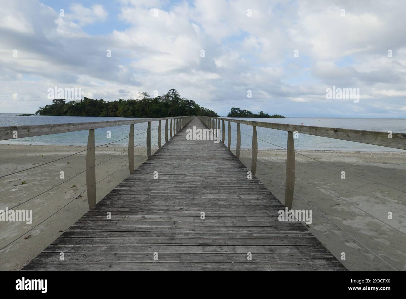 Bridge that connects an island with the coast of Equatorial Guinea in Malabo surrounded by water and green vegetation Stock Photo