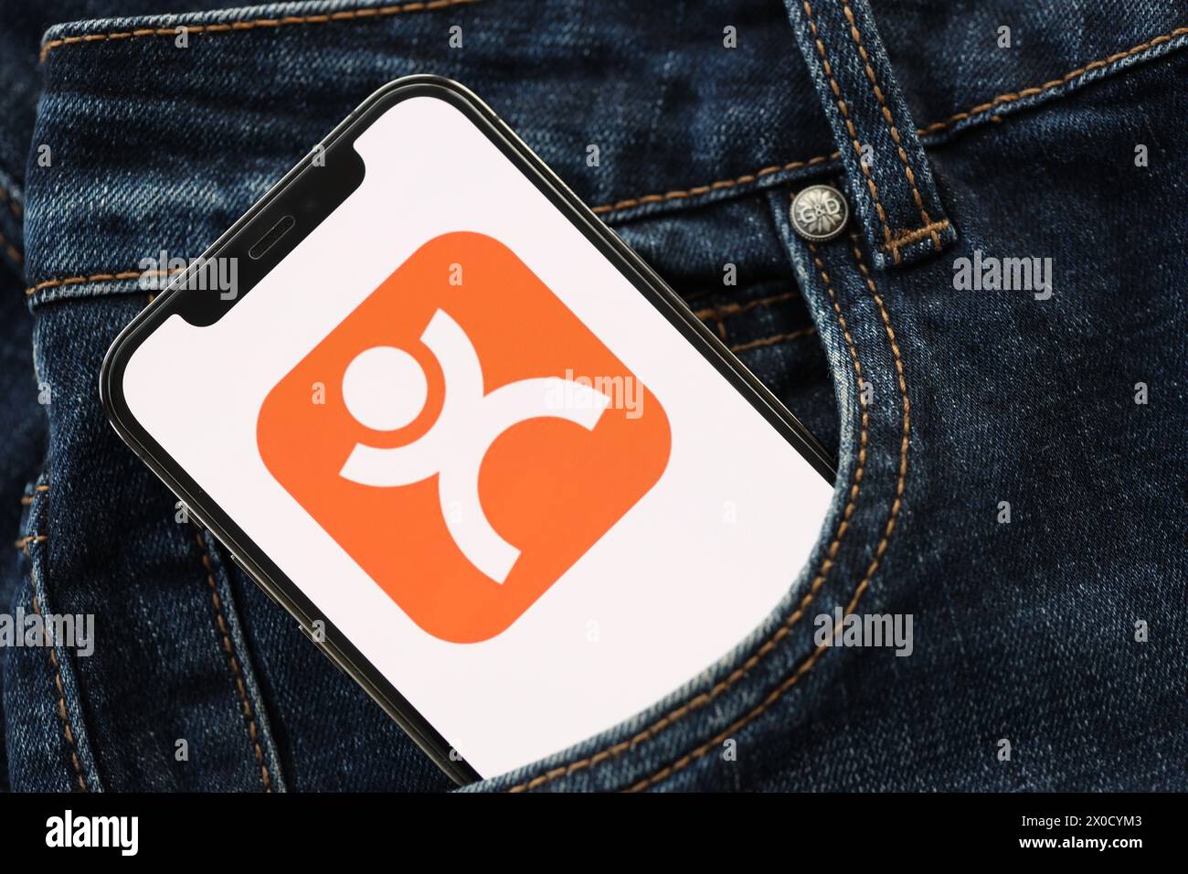 KYIV, UKRAINE - APRIL 1, 2024 Dianping platform icon on smartphone display screen in jeans pocket. iPhone display with app logo hide in fashionable denims pocket close up Stock Photo