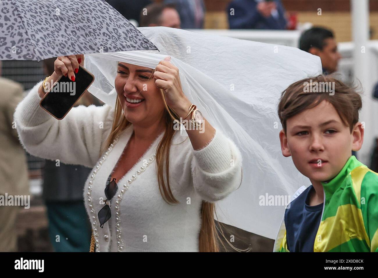 Randox Cover A racergoer takes cover as it begins to rain during the Randox Grand ...