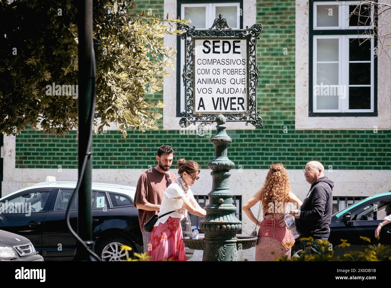 A sign reads "Be compassionate with the poor animals who help us to live" on a street in Lisbon, Portugal Stock Photo