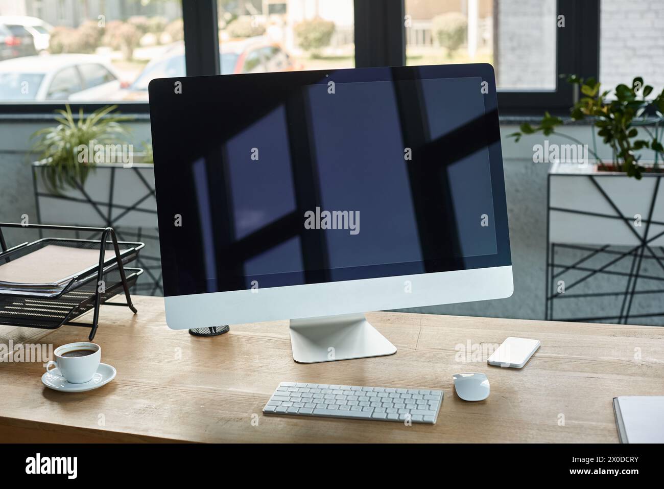 A sleek desktop computer rests atop a wooden desk in a modern office setting, embodying a tech-savvy and organized workspace. Stock Photo