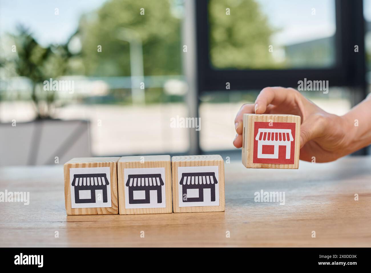 A businesswoman joyfully arranges wooden blocks engraved with symbols, exploring the art and culture they represent. Stock Photo