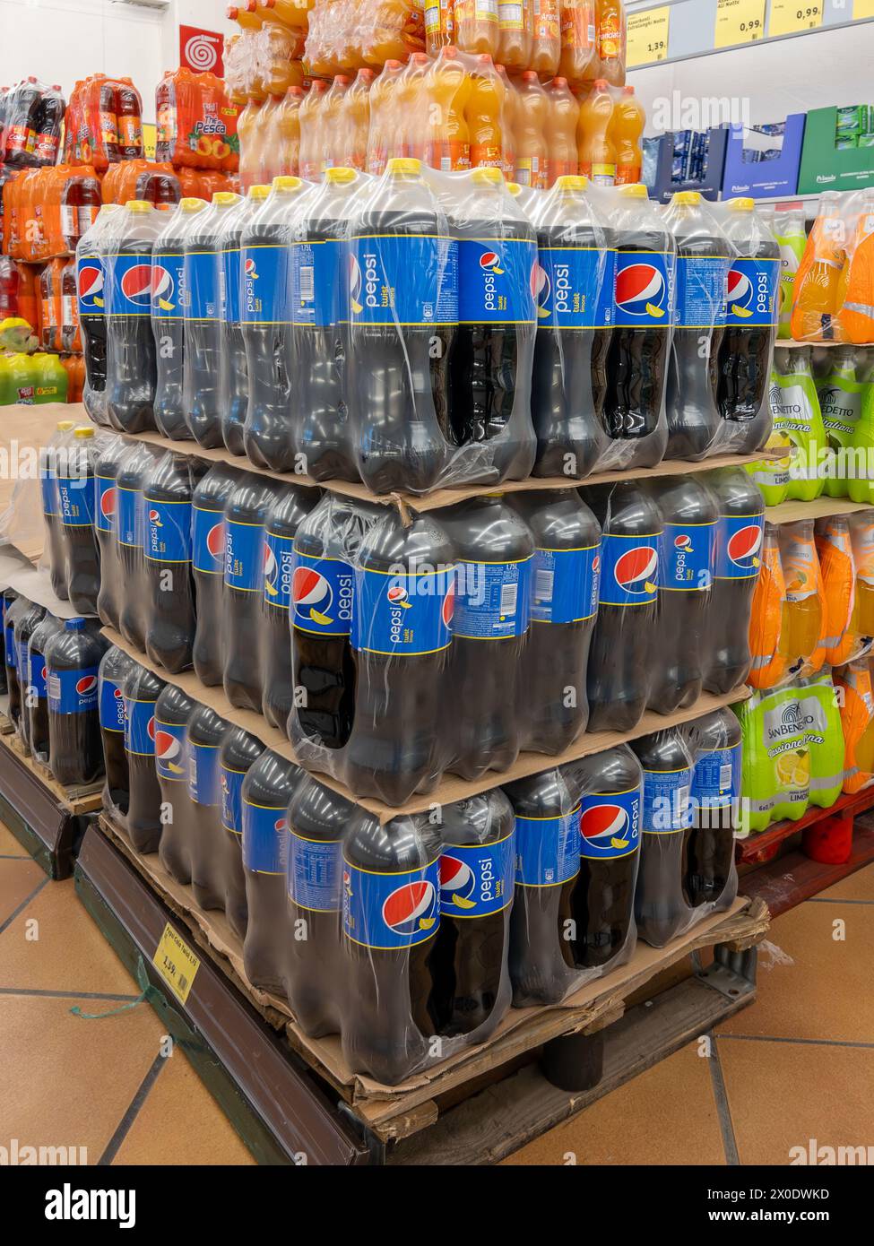 Italy - April 11, 2023: Pepsi Twist, Lemon-flavored cola in plastic bottles stacked on pallet for sale in Italian discount store Stock Photo