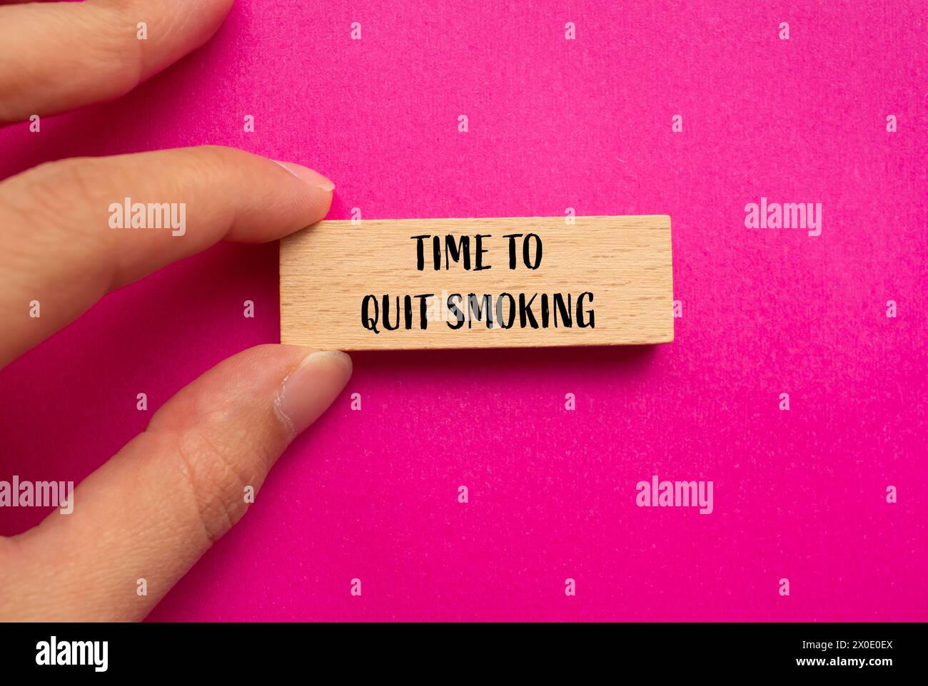 Time to quit smoking words written on wooden block with pink background. Conceptual time to quit smoking symbol. Copy space. Stock Photo