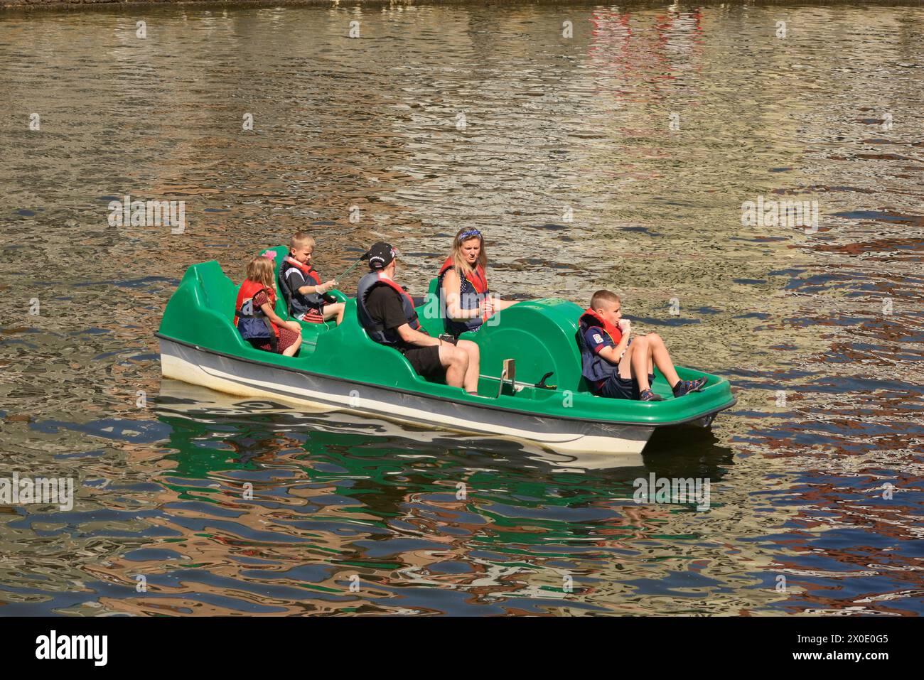 Family of five on vacation paddling with pedalo paddle boat in Motlawa River in the Old Town of Gdansk, Poland Stock Photo