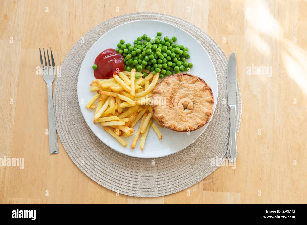 Traditional Pie Dinner-pie with chips, ketchup and peas Stock Photo