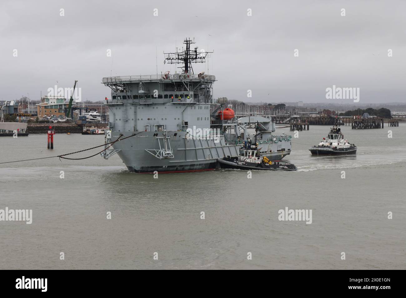Tugs assist the decommissioned Royal Fleet Auxiliary repair ship DILIGENCE as it is towed out of harbour to a Turkish breaker’s yard Stock Photo